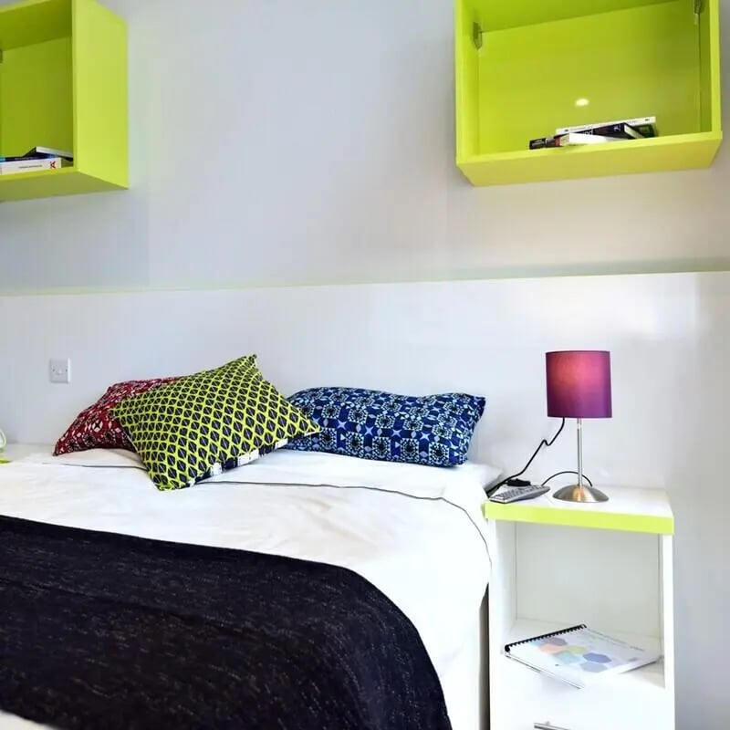 Bed with colorful pillows and lamp bedroom at The Courtyard Block C in Huddersfield Student Accommodation