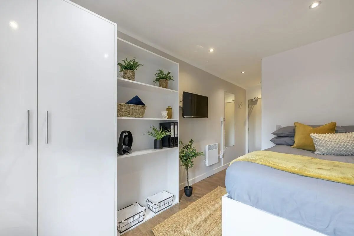 White wardrobe shelves plant television bed bedroom at Hope Street in Liverpool Student Accommodation