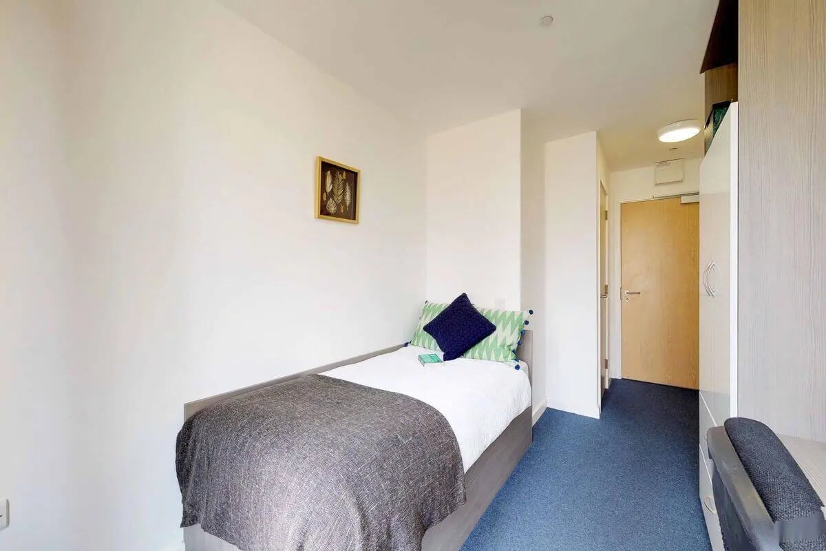 Bed with patterned pillows grey throw framed art bedroom at Haymarket Edinburgh in Edinburgh Student Accommodation