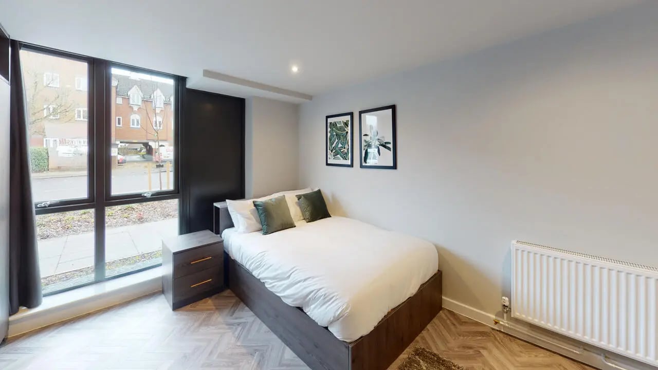 Bed with nightstand, window, art. Bedroom. at Astra House in London Student Accommodation