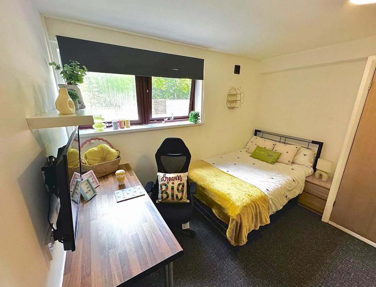 Bed desk chair pillows and yellow blanket bedroom at Forest Court in Loughborough Student Accommodation