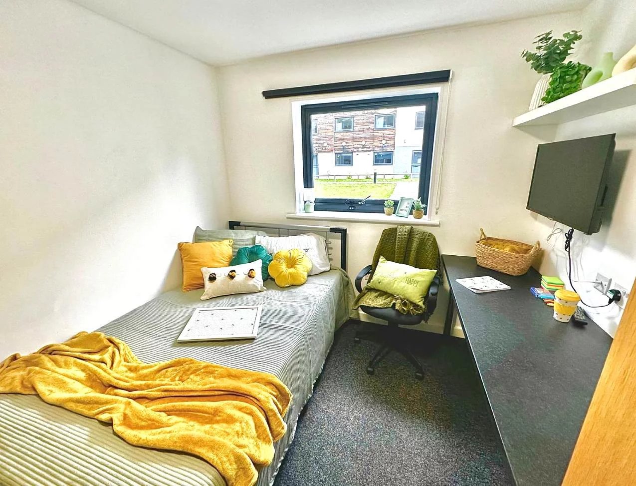 Bed with yellow blanket and colorful pillows bedroom at Forest Court in Loughborough Student Accommodation