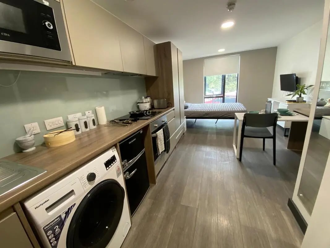 Kitchen washing machine bed table living area studio at Sycamore House in Leeds Student Accommodation