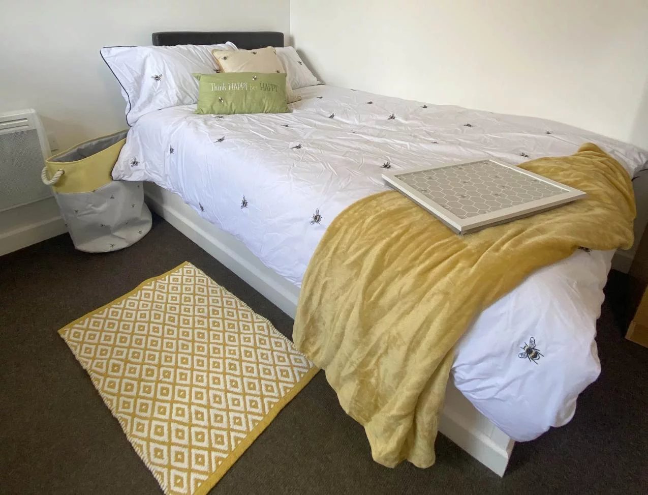 Bed with bee print bedding yellow throw rug bedroom at The Student Block in Loughborough Student Accommodation