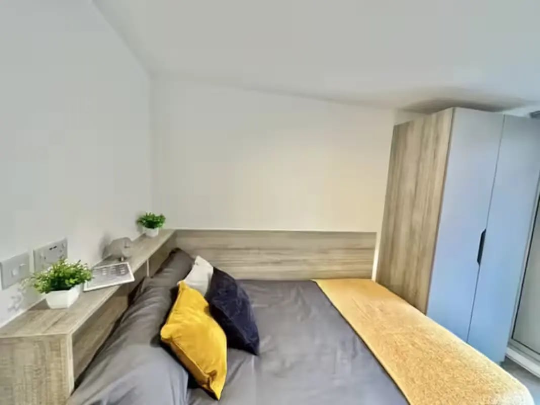 Bed with pillows shelf and wardrobe bedroom at Albany Student Village in Coventry Student Accommodation