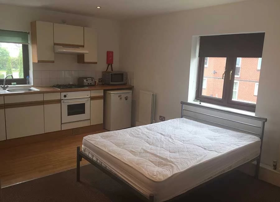 Bed kitchen cabinets oven microwave and mini-fridge studio at Kingfisher Halls in Loughborough Student Accommodation