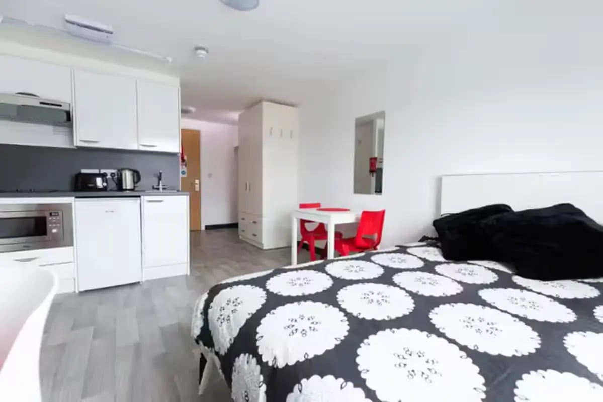 Bed microwave kettle dining table wardrobe living room at Julian Court in Coventry Student Accommodation