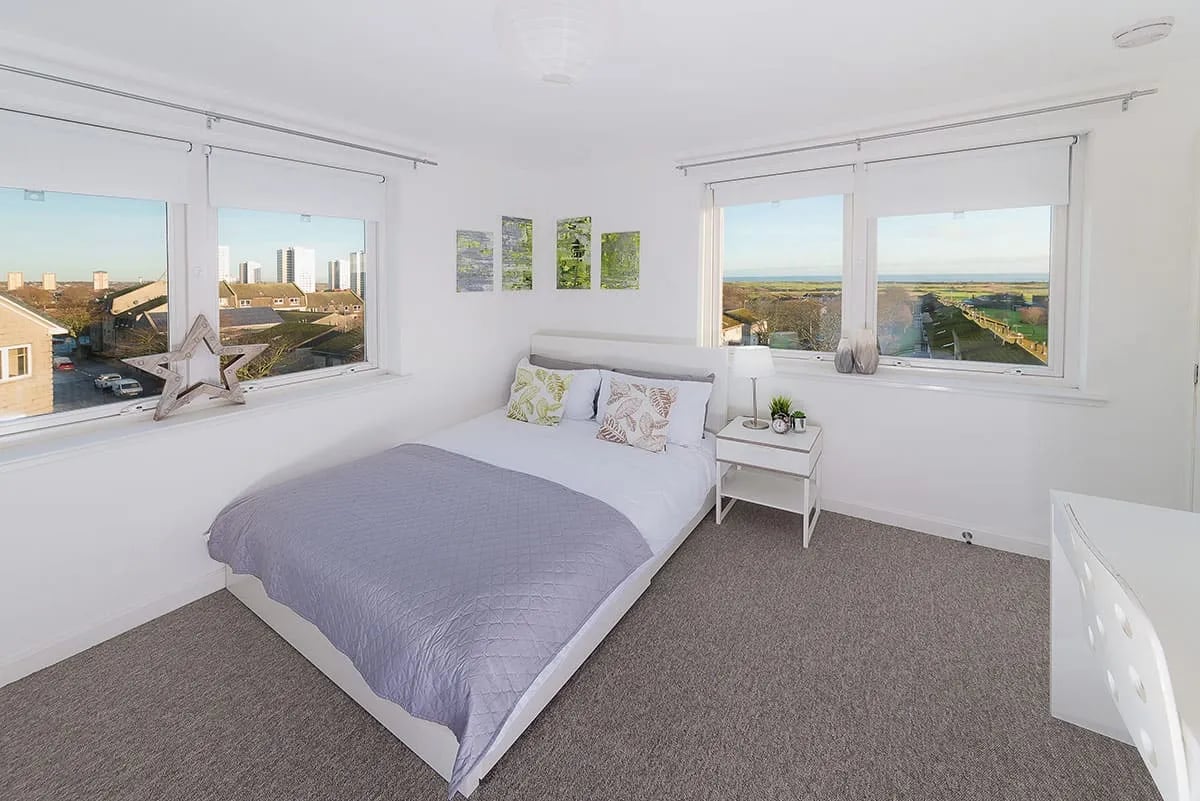 Bed with patterned pillows and grey quilt bedroom at Trinity Court in Aberdeen Student Accommodation