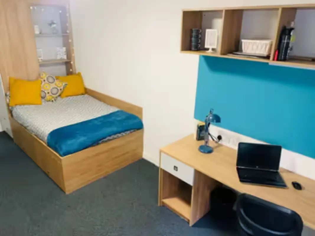 Bed with pillows desk with laptop bedroom at Pennine House Leicester in Leicester Student Accommodation