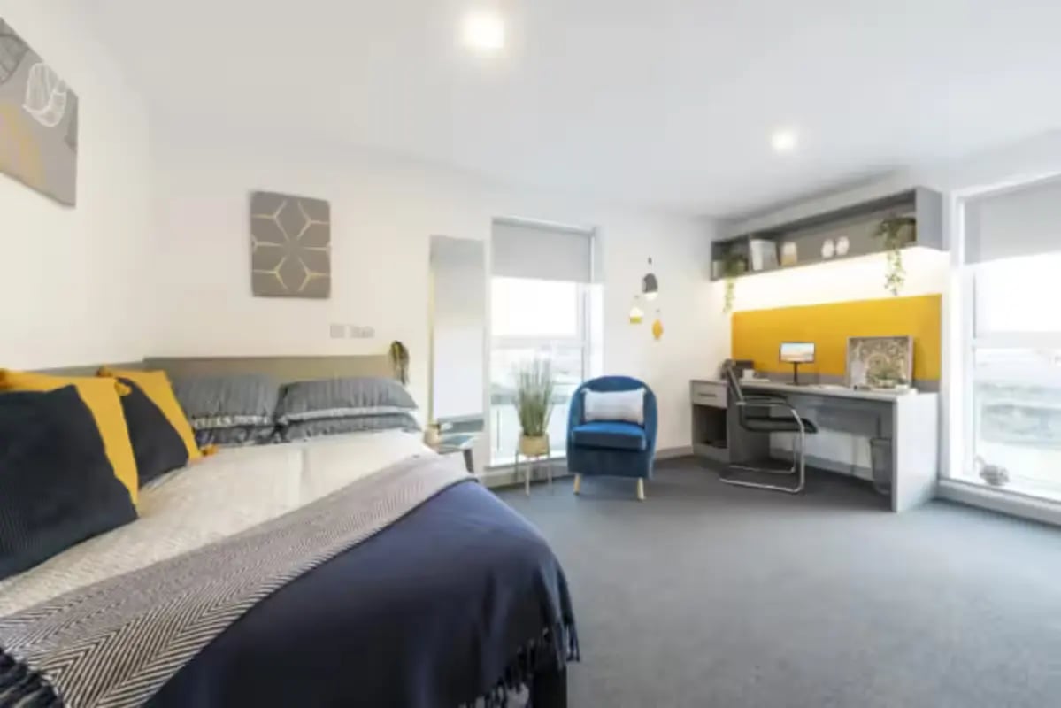 Bed desk chair and blue armchair Bedroom at Pine Mill in Lincoln Student Accommodation