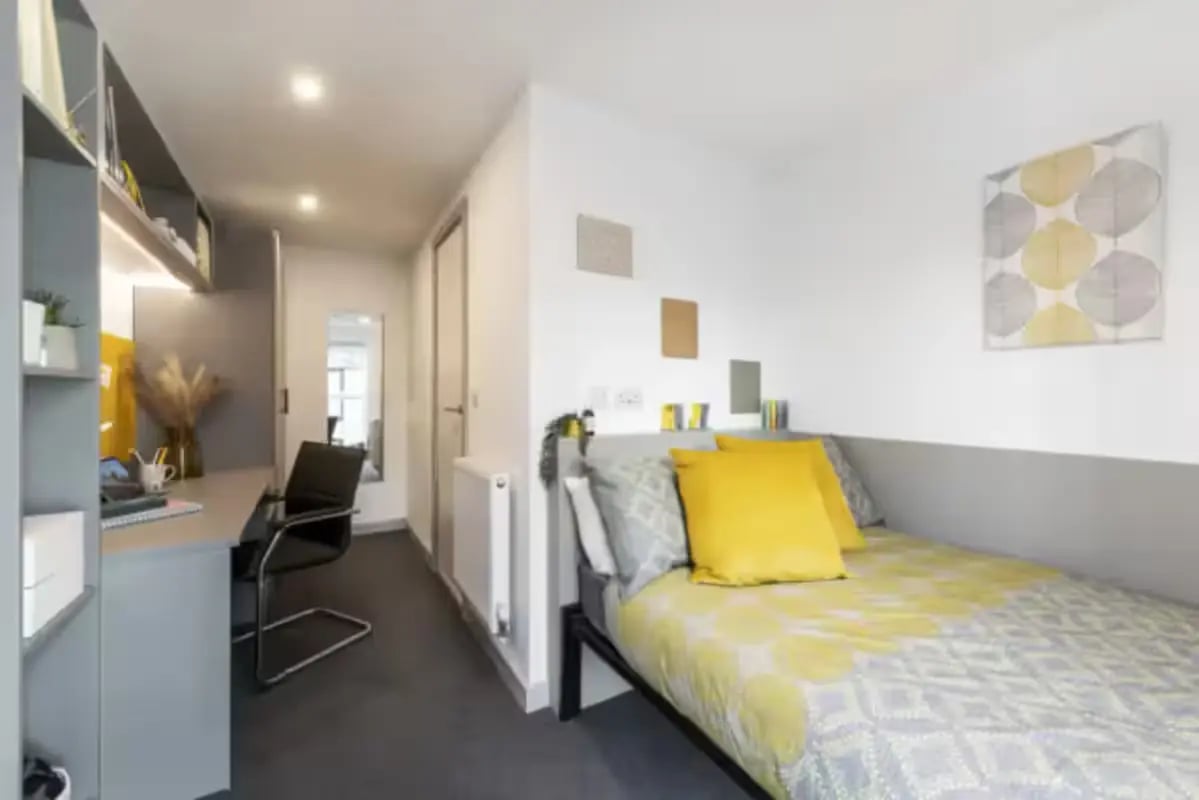 Desk chair bed with yellow pillows bedroom at Pine Mill in Lincoln Student Accommodation