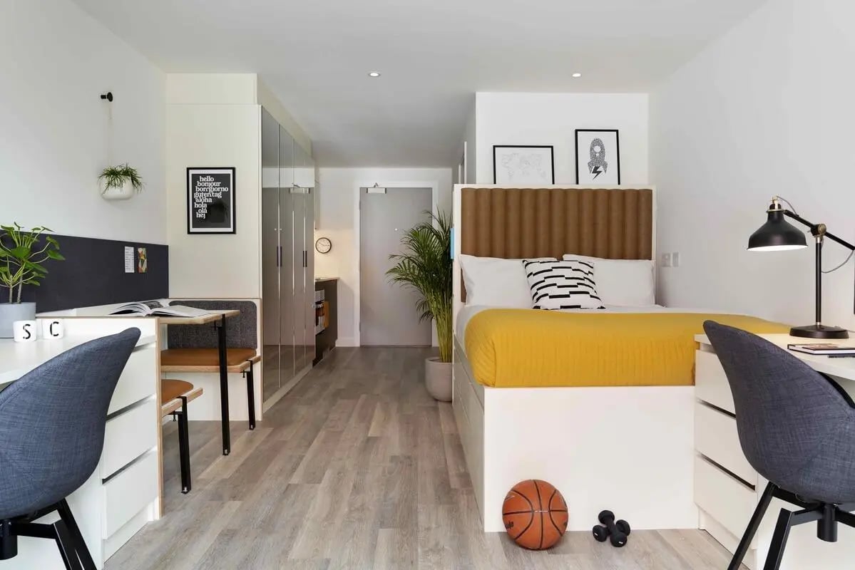 Modern student room with bed desk storage and basketball. at Student Castle Brighton in Brighton Student Accommodation