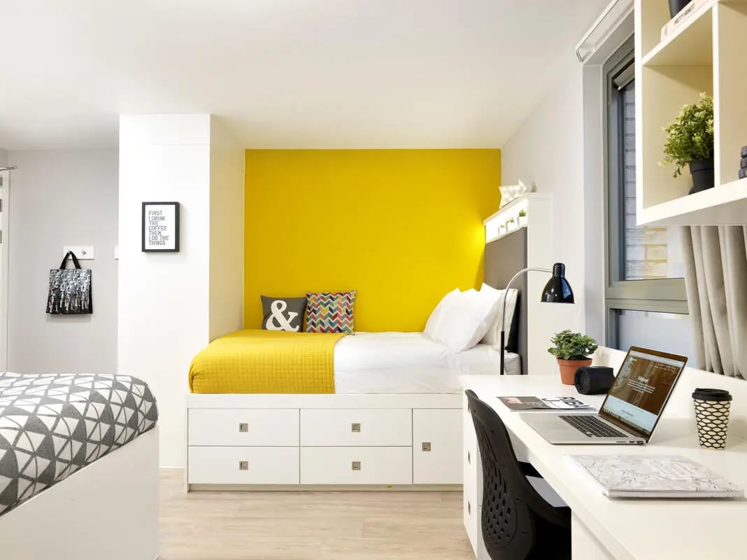 Bed with yellow blanket and desk bedroom at Student Castle Edinburgh in Edinburgh Student Accommodation