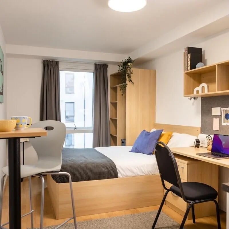 Bed desk wardrobe with laptop and chairs bedroom at Prince Consort Village in London Student Accommodation