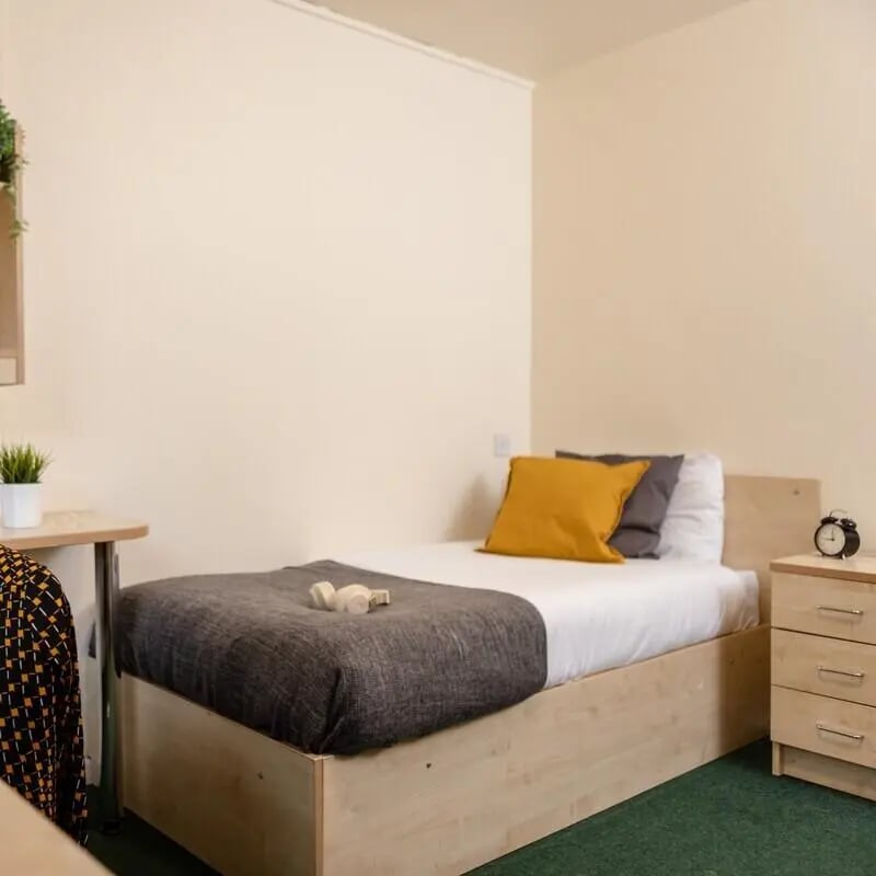 Bed with pillows desk and alarm clock bedroom at Bonington Student Village in Loughborough Student Accommodation