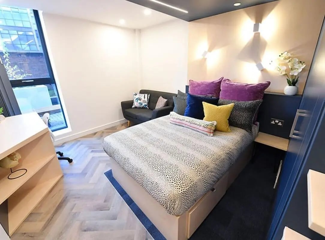 Bed sofa desk and pillows bedroom at The Orchard in Leicester Student Accommodation