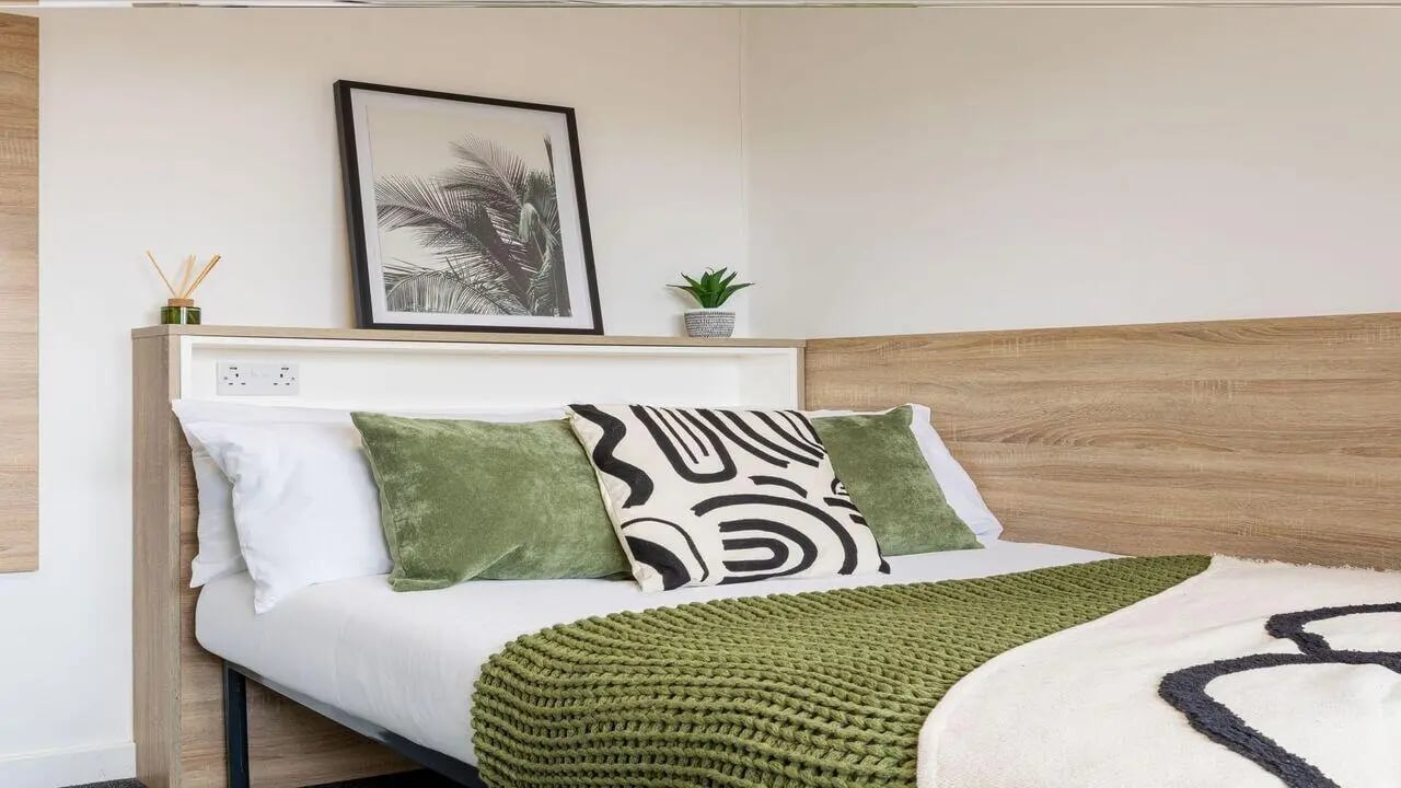 Bed with green pillows artwork and bedding bedroom at dwell Cathedral Campus in Liverpool Student Accommodation