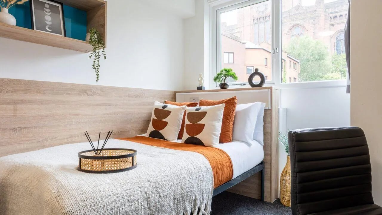 Bed with patterned pillows and diffuser bedroom at dwell Cathedral Campus in Liverpool Student Accommodation