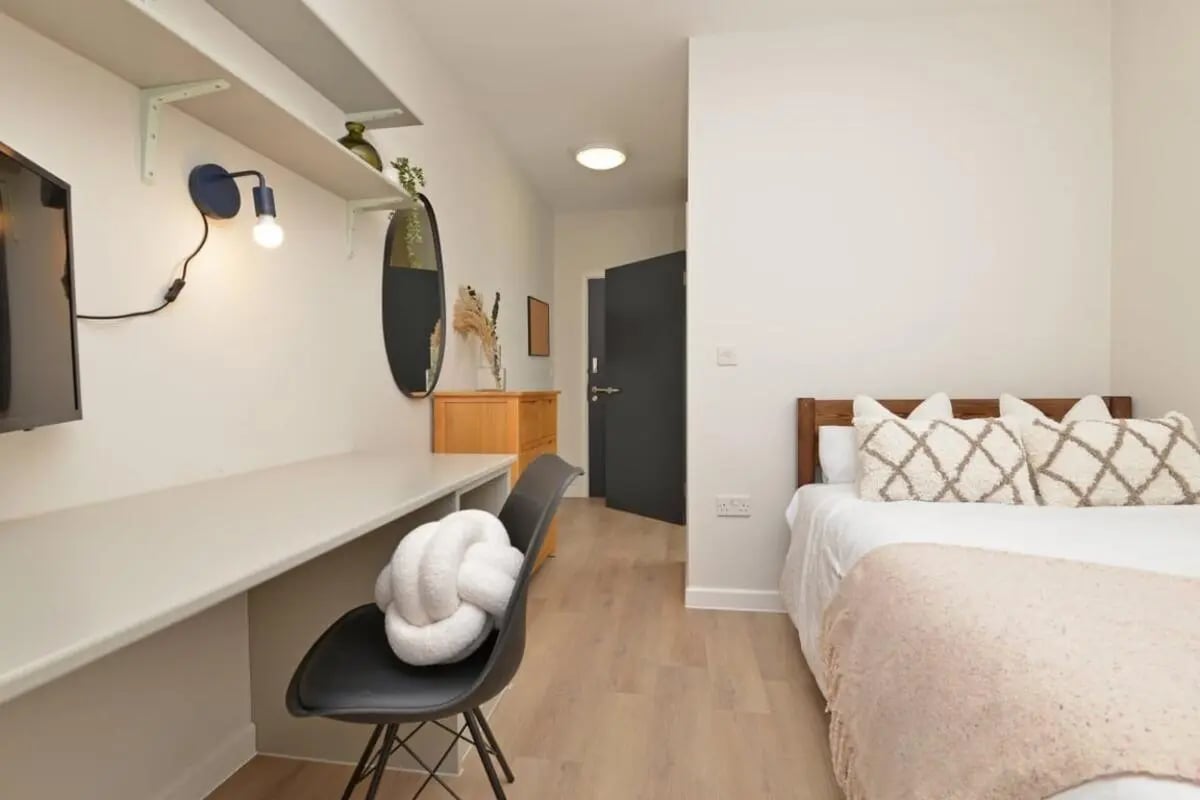 Desk chair bed and pillows bedroom at Isca Lofts in Exeter Student Accommodation