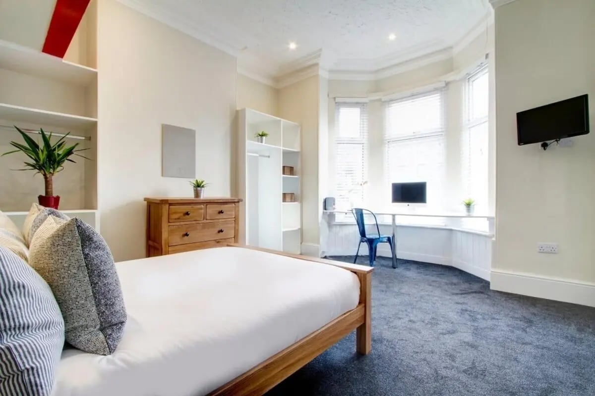 Bed dresser shelves computer blue chair bedroom at 131 Hyde Park in Leeds Student Accommodation