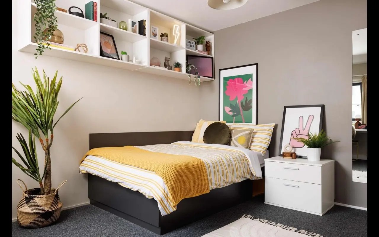 Bed with yellow blanket and plant bedroom at Exchange Works in Sheffield Student Accommodation