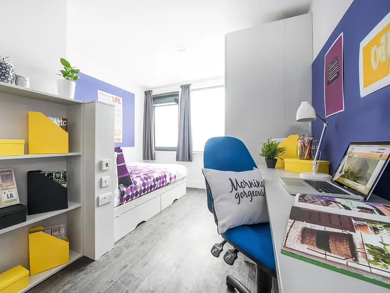 Bed desk chair bookshelf and laptop bedroom study area at Yugo Ablett House in Liverpool Student Accommodation