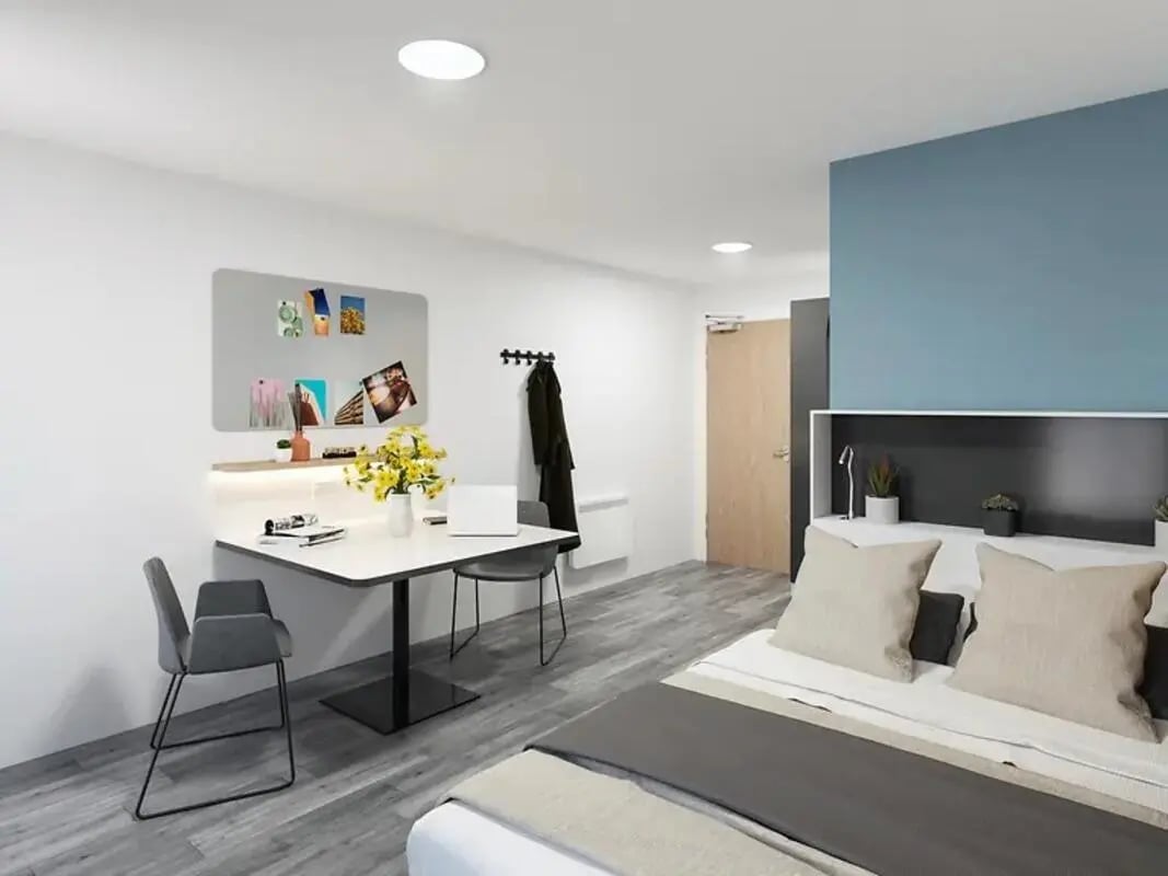 Desk with laptop flowers and chairs Bedroom at Depot Point in London Student Accommodation