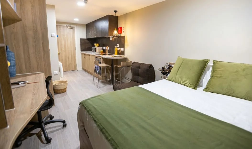 Desk bed kitchen stool and pillows studio apartment at St Peter's Hall in Bournemouth Student Accommodation