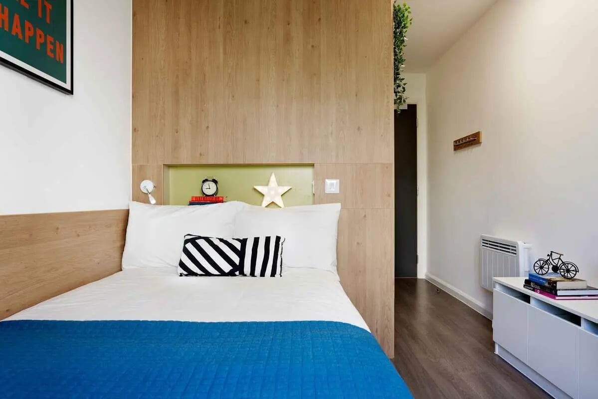 Bed with blue blanket alarm clock star bedroom at Hampton Square in Southampton Student Accommodation