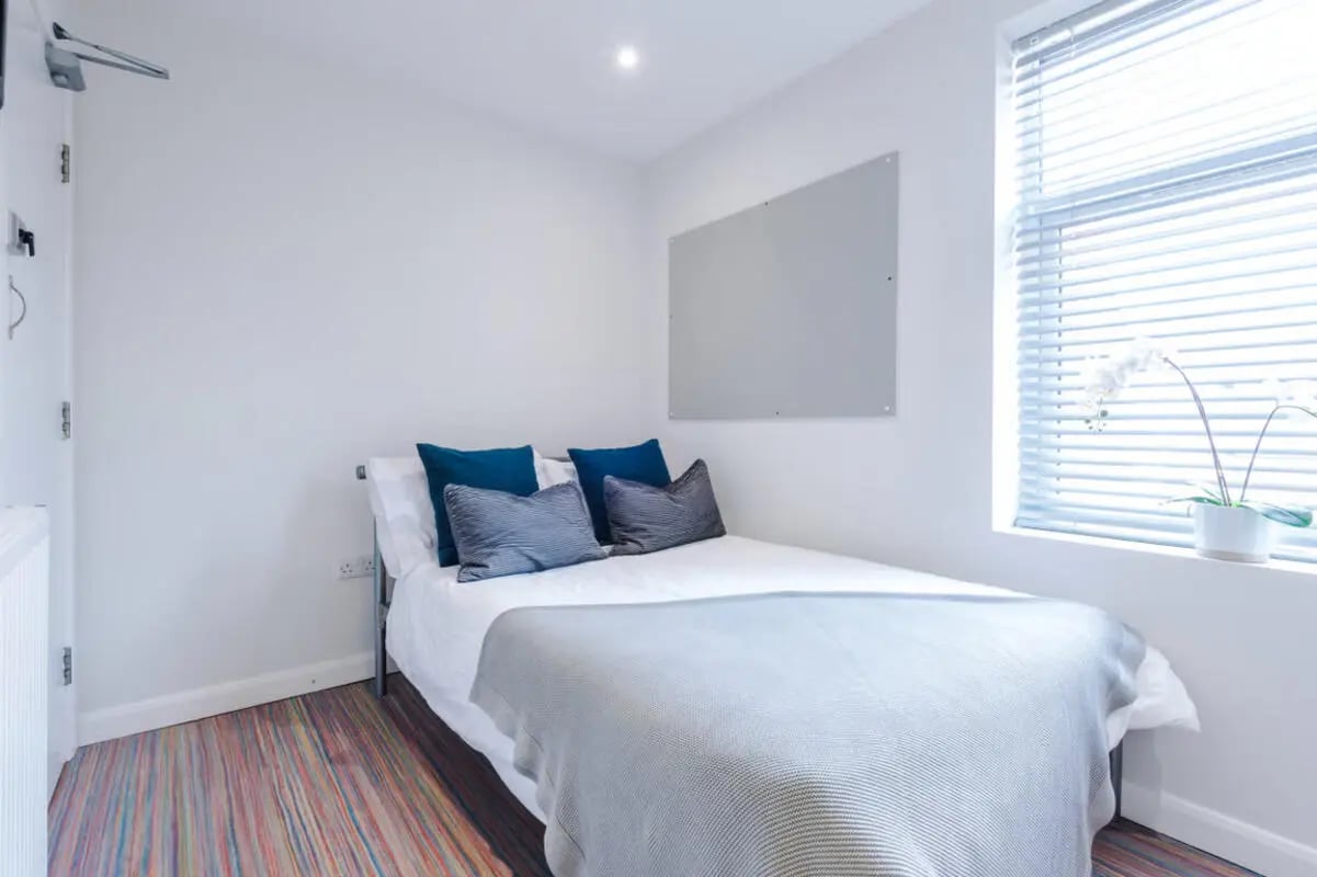 Bed with pillows and blanket whiteboard window bedroom at 90 Ashford Street in Stoke-On-Trent Student Accommodation