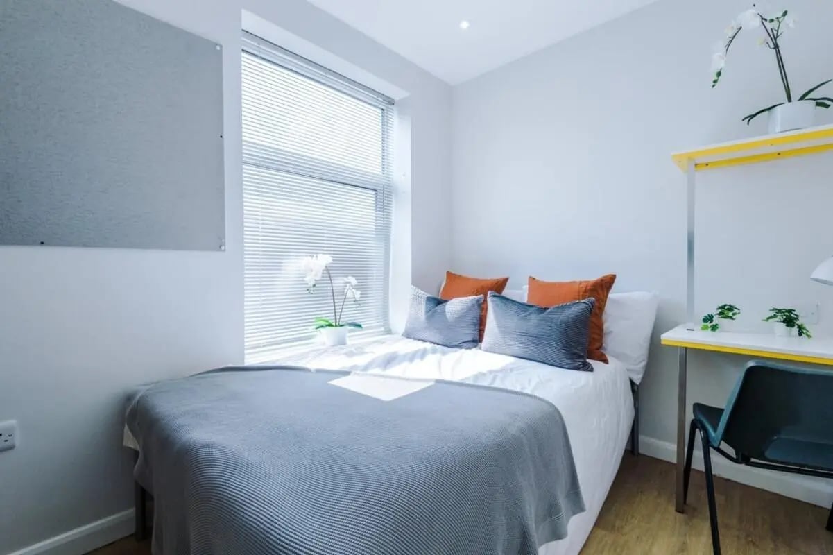 Bed with orange and blue pillows study desk bedroom at 32 Cauldon Road in Stoke-On-Trent Student Accommodation