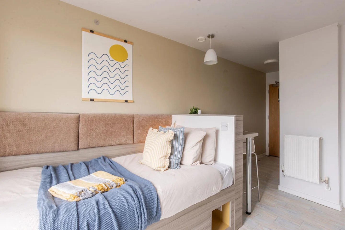 Bed with blue blanket and pillows bedroom at Merlin Point in Coventry Student Accommodation