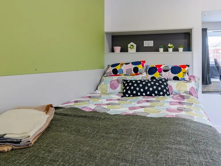 Colorful patterned pillows on bed bedroom. at Yugo Crescent Place in Southampton Student Accommodation