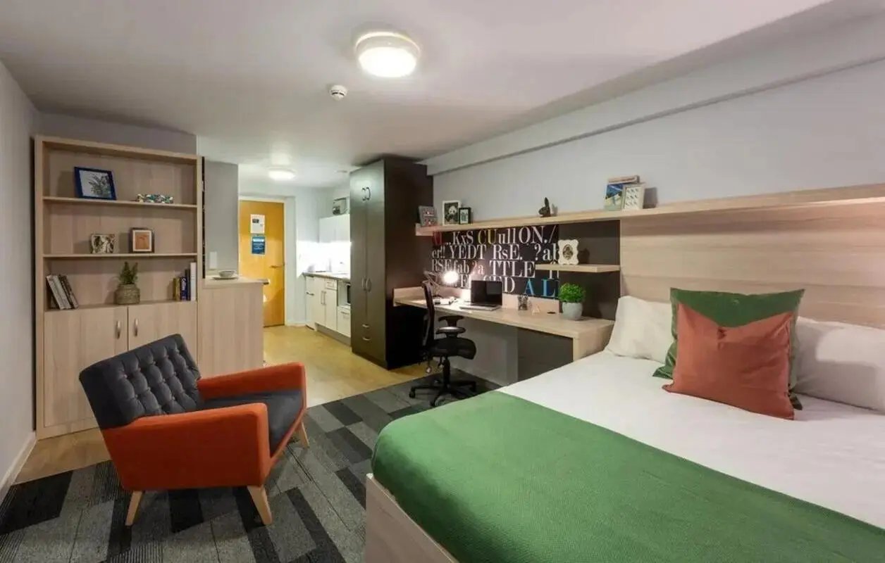 Bed desk chair bookshelf and kitchenette studio at The Electra in Liverpool Student Accommodation