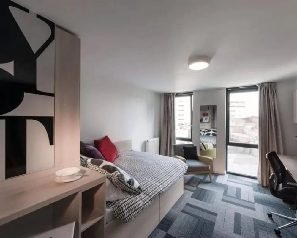 Bed with patterned duvet chair desk bedroom at The View - Newcastle in Newcastle Upon Tyne Student Accommodation