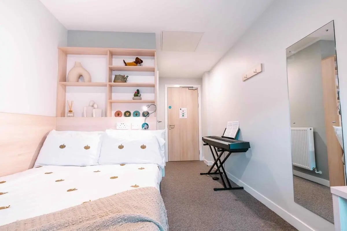 Bed with pumpkins keyboard and shelves bedroom at Base in Glasgow Student Accommodation