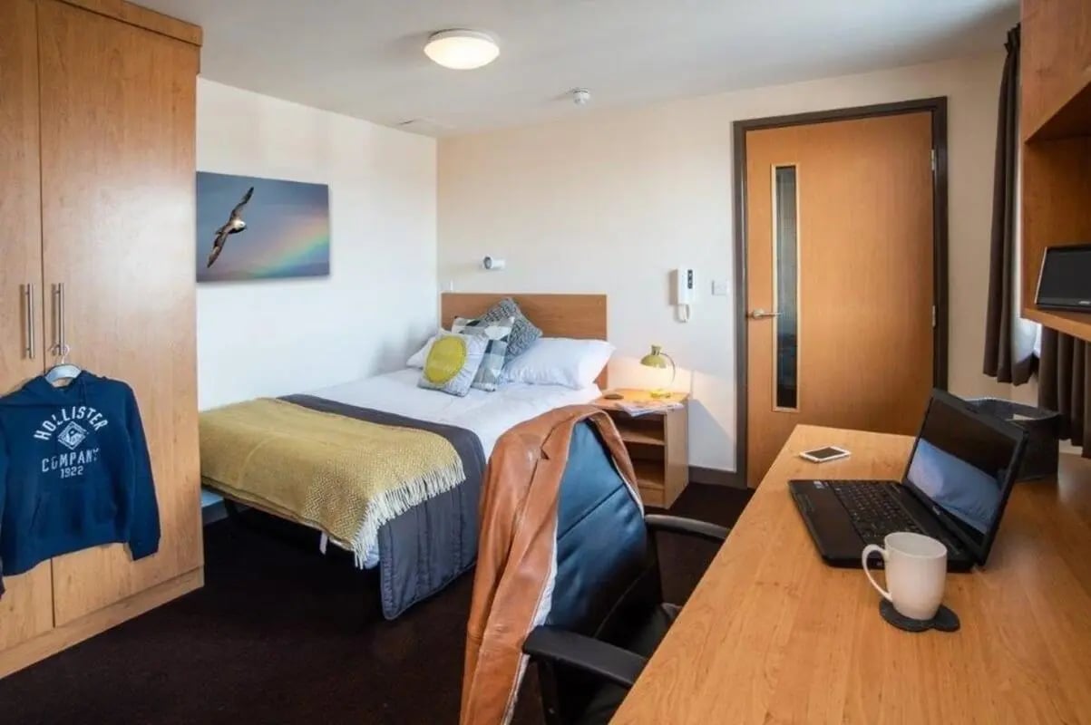 Bed wardrobe desk with laptop and mug bedroom at Asha House in Loughborough Student Accommodation