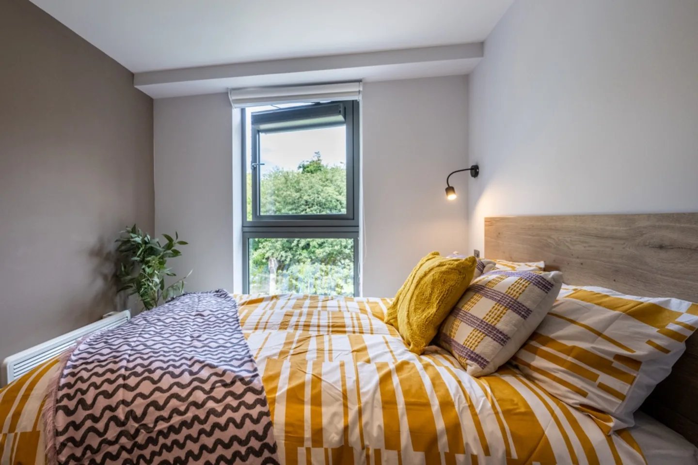 Bed with yellow patterned bedding bedside lamp bedroom at Murieston Crescent - Edinburgh in Edinburgh Student Accommodation