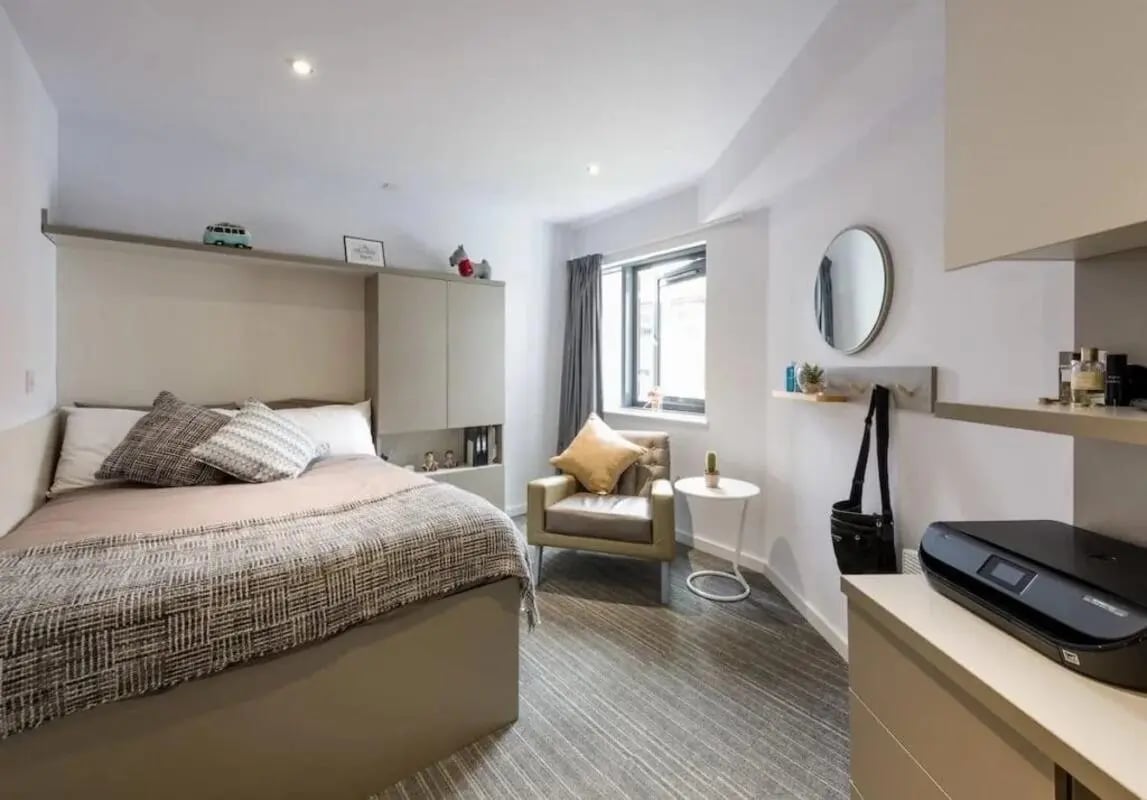 Bed armchair printer shelves and window bedroom at The Kingfisher in Exeter Student Accommodation