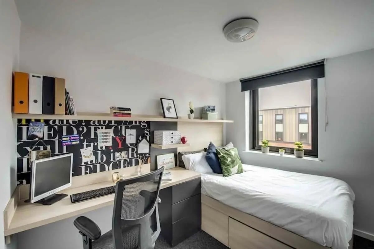 Desk bed plants and binders bedroom at West Village in Glasgow Student Accommodation