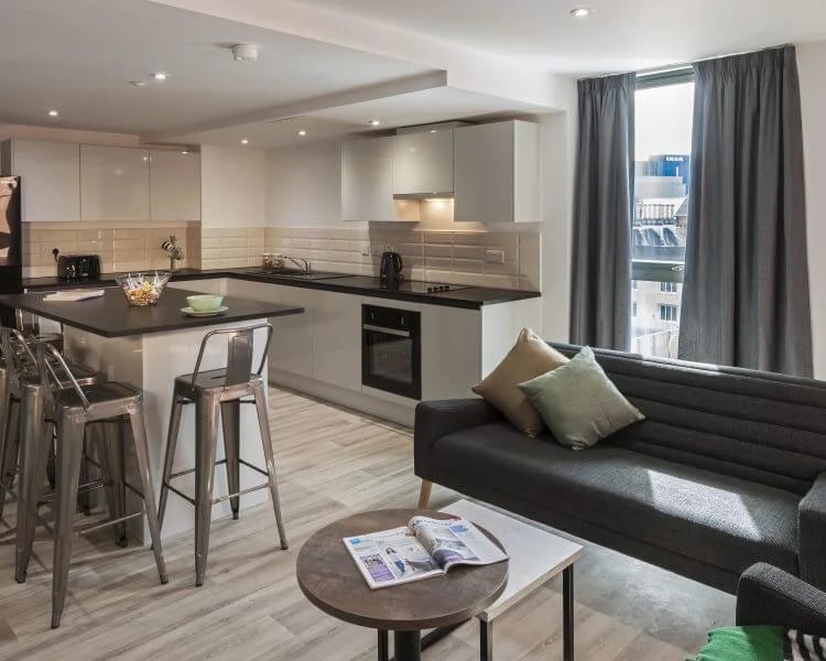 Sofa kitchen counter stools and window living area at City Village in Coventry Student Accommodation