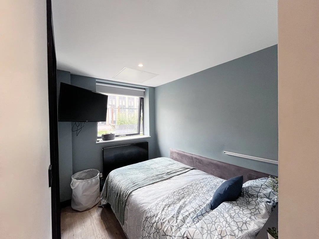 Bed TV laundry basket window bedroom at Luna Hatfield in Hatfield Student Accommodation