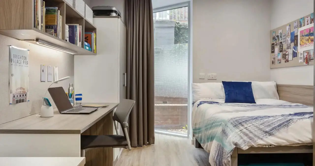 Desk laptop bed blue pillow bedroom at Kaplan Living Brighton in Brighton Student Accommodation