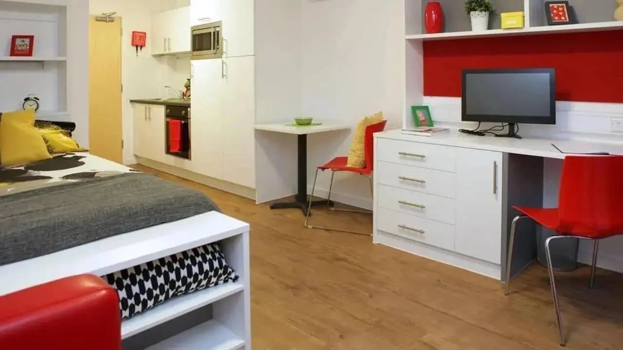 Bed kitchen desk and red chairs living room at Grenville Street in Liverpool Student Accommodation