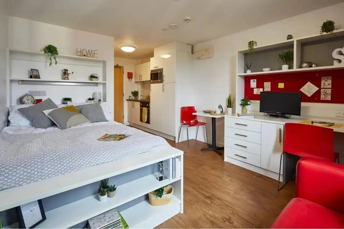 Bed desk kitchenette and red chairs studio at Grenville Street in Liverpool Student Accommodation