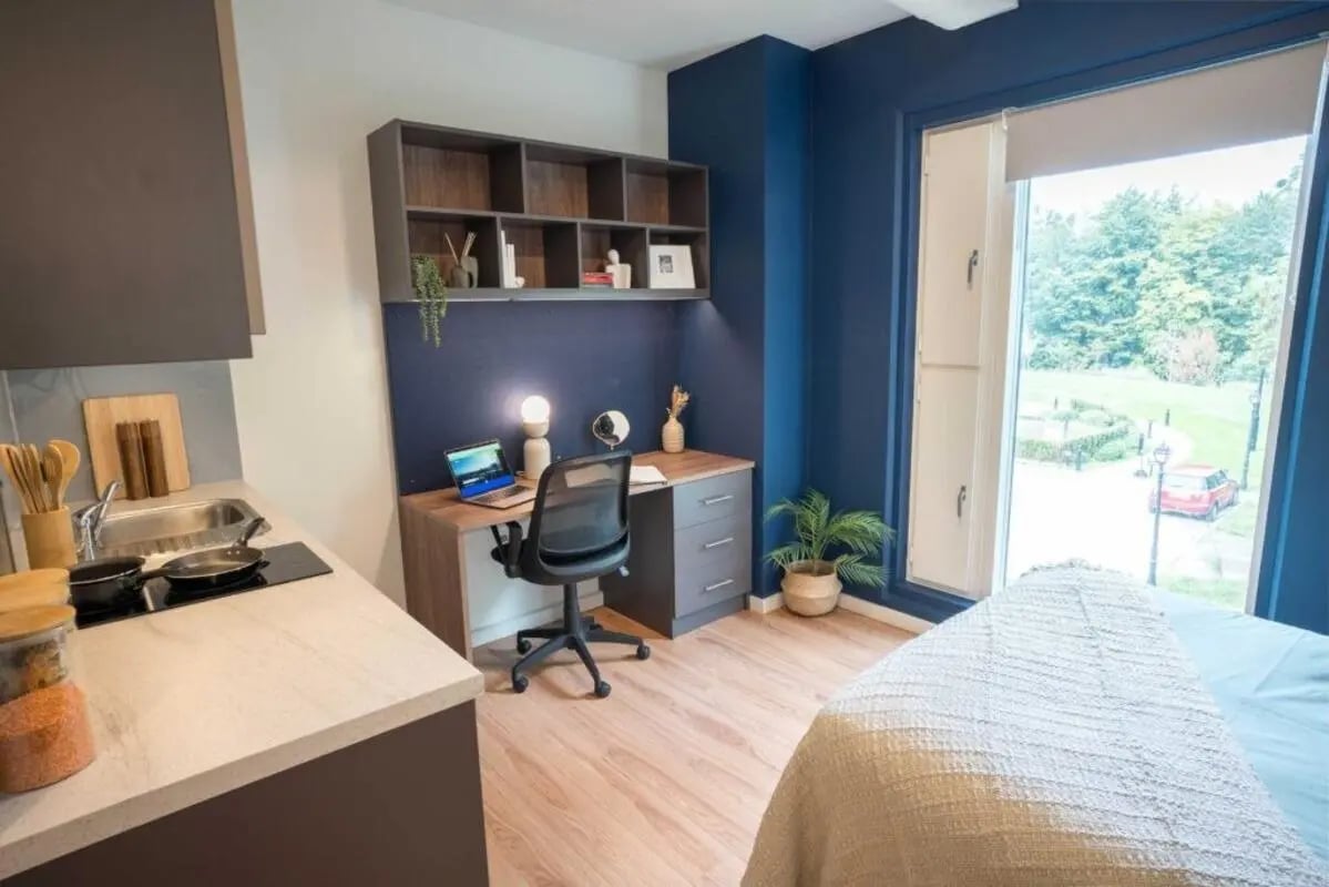 Desk laptop chair shelves kitchen area bedroom at Hox Park in Egham Student Accommodation
