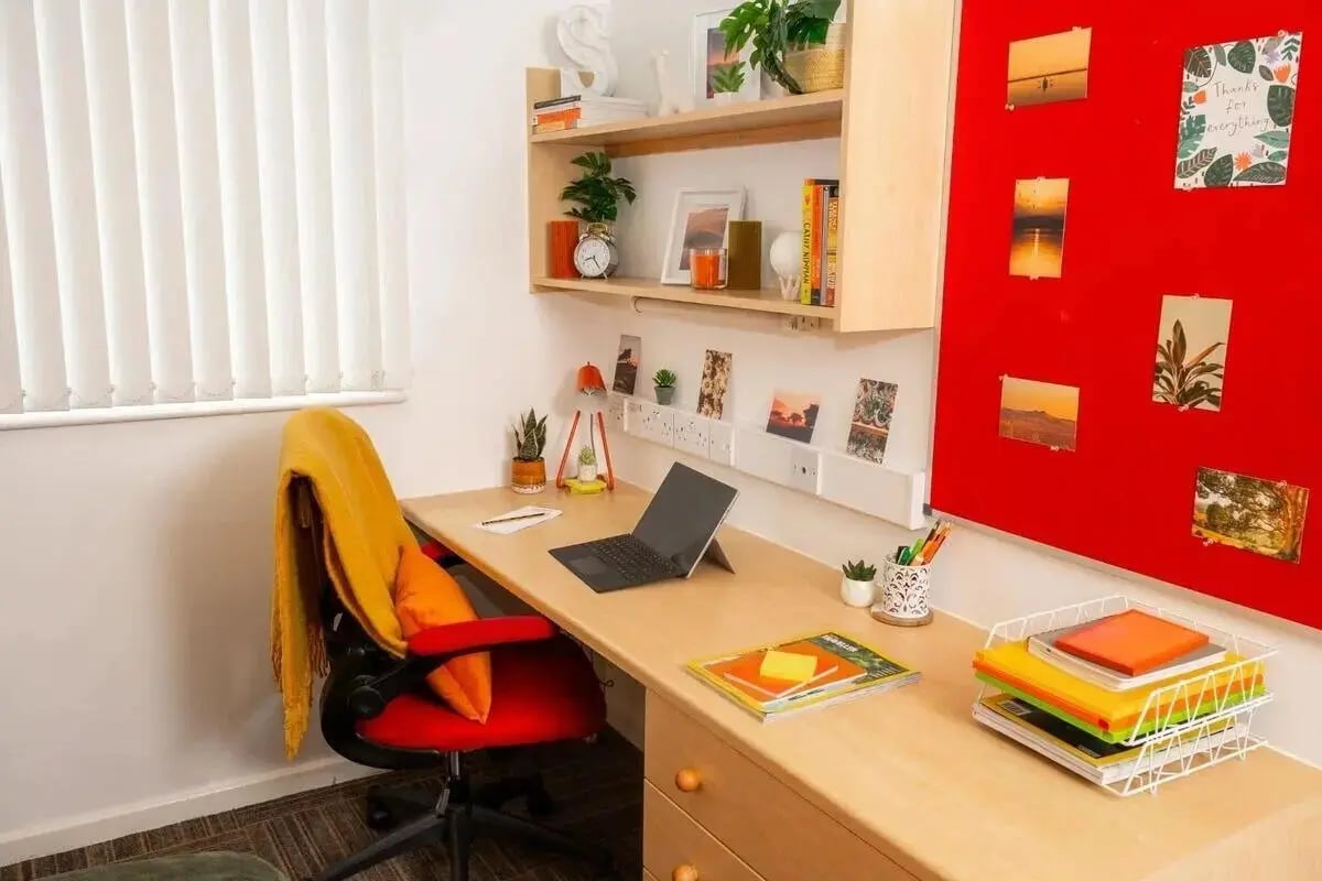 Desk with laptop red chair yellow blanket study area at Marybone Student Village 2 in Liverpool Student Accommodation