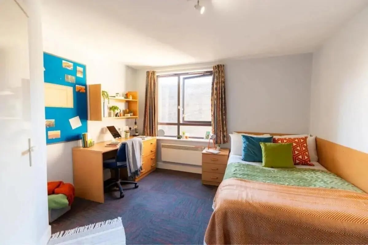 Bed desk chair and cork board bedroom at Coopers Court in London Student Accommodation