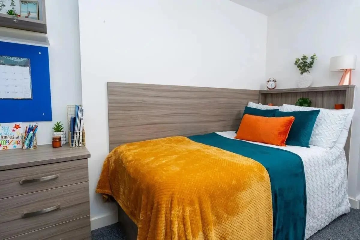 Bed with orange teal blankets and desk Bedroom at Grafton Street in Manchester Student Accommodation