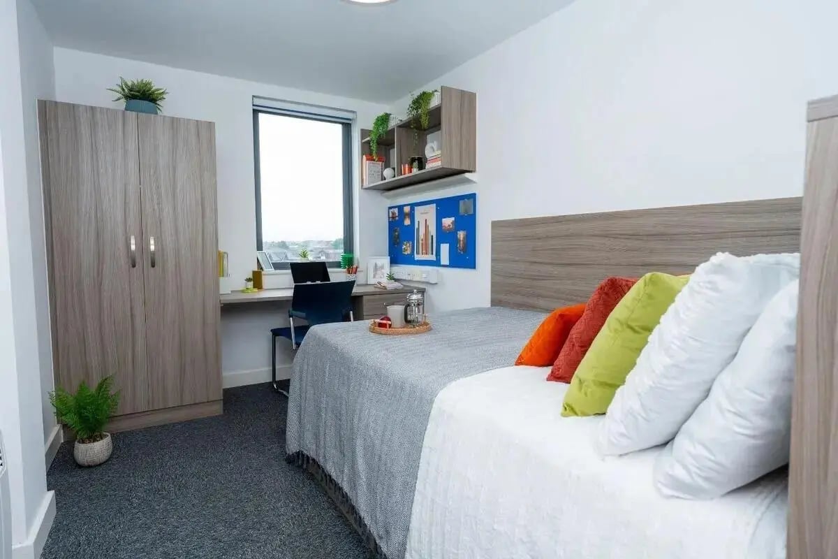 Wardrobe desk and bed with pillows Bedroom at Grafton Street in Manchester Student Accommodation